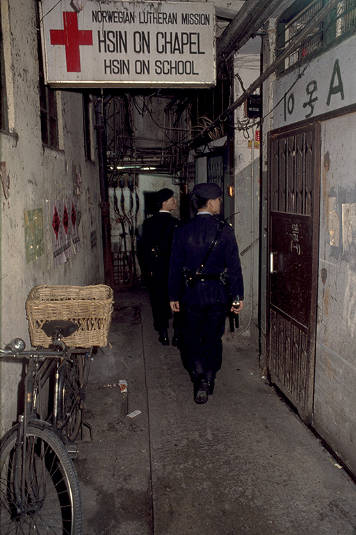 Policemen patrol one of the cleaner ground-floor alleys.